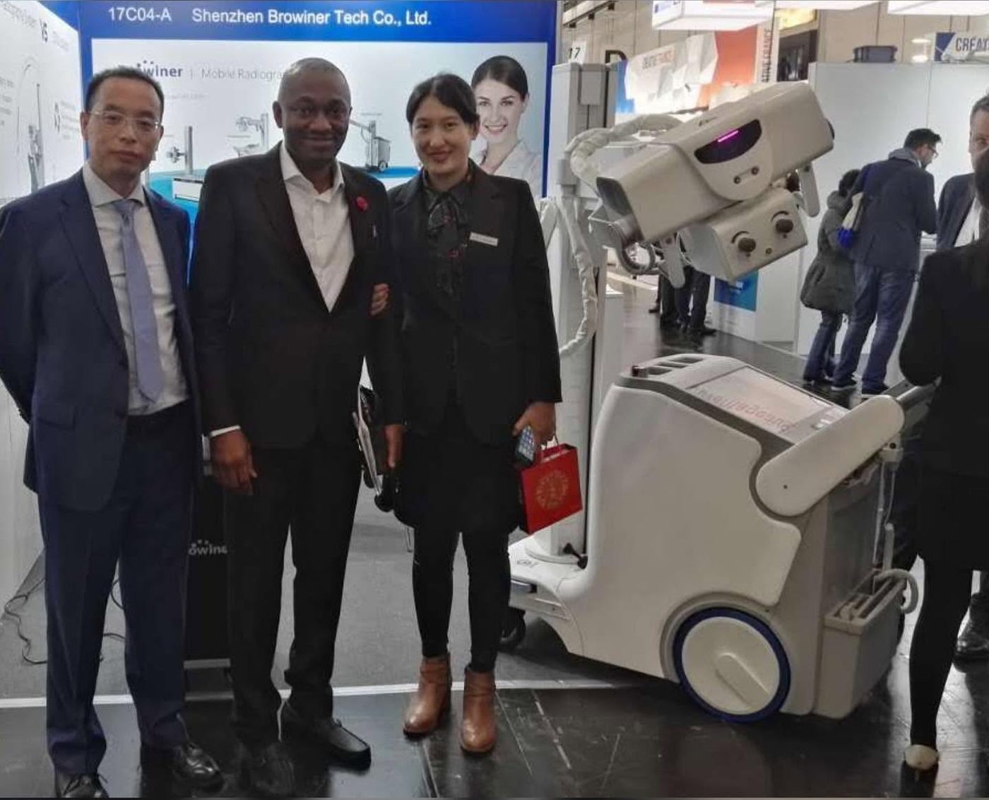 Biofig team member with manufacturer representatives beside a mobile radiography system